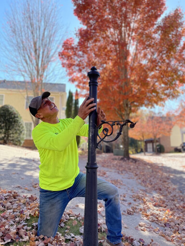 Image of a repairperson fixing a mailbox post in the fall.